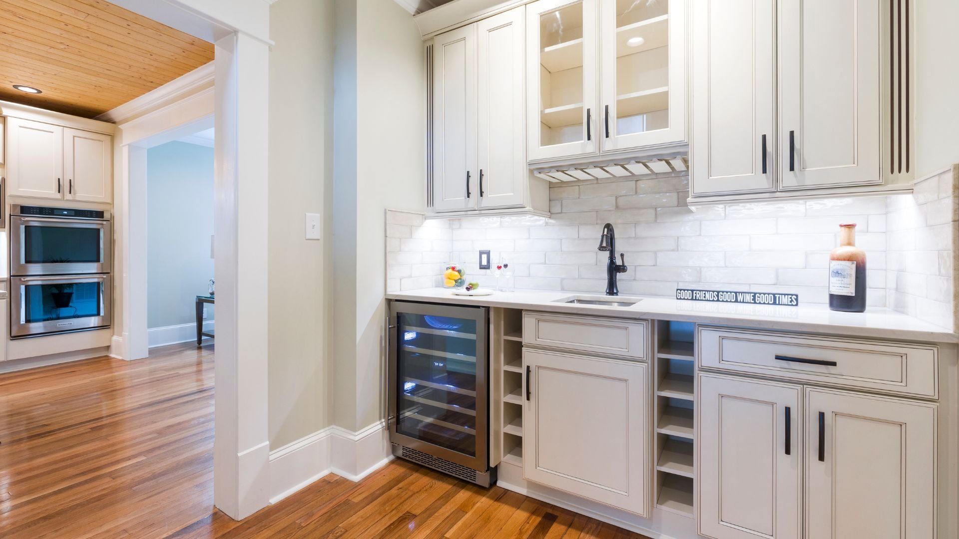 Modern white kitchen with wood floors and wine cooler